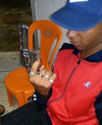 Suspeito exibe arma (Foto: Divulgação/Polícia Civil)