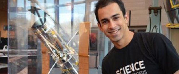 Walysson Vital ao lado de uma miniatura do Telescópio Hubble