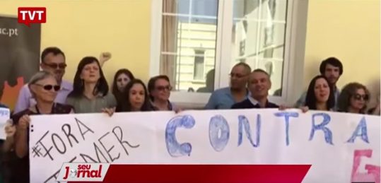 A subprocuradora da República Ela Wiecko (à esq, segurando a faixa, de óculos escuros) participa em Portugal de ato de protesto ao governo Temer (Foto: Reprodução / TVT)